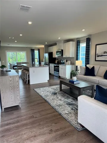 a living room with furniture and a wooden floor