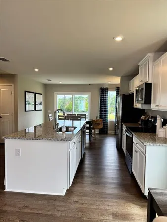 a large kitchen with stainless steel appliances a lot of counter space and wooden floor