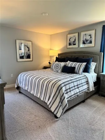 a bedroom with a bed and painting on the wall