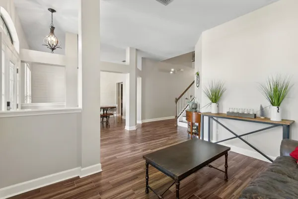 a view of a hallway with wooden floor and furniture