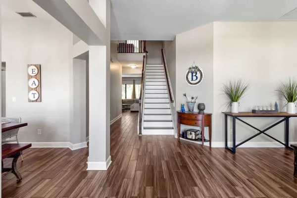 a view of a hallway with wooden floor and windows