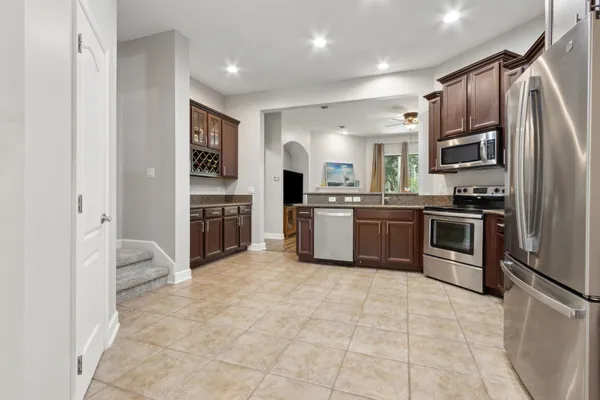 a kitchen with granite countertop a stove a cabinets and wooden floor