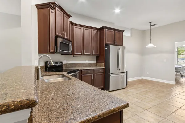 a kitchen with stainless steel appliances granite countertop a sink and a refrigerator