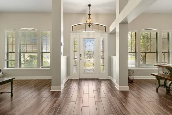 a view of a room with wooden floor glass door and windows