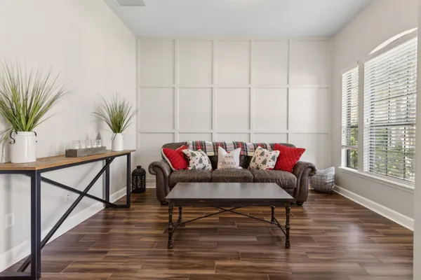 a living room with furniture and a wooden floor