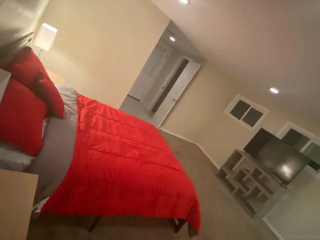 a bed sitting in a bedroom next to a lamp