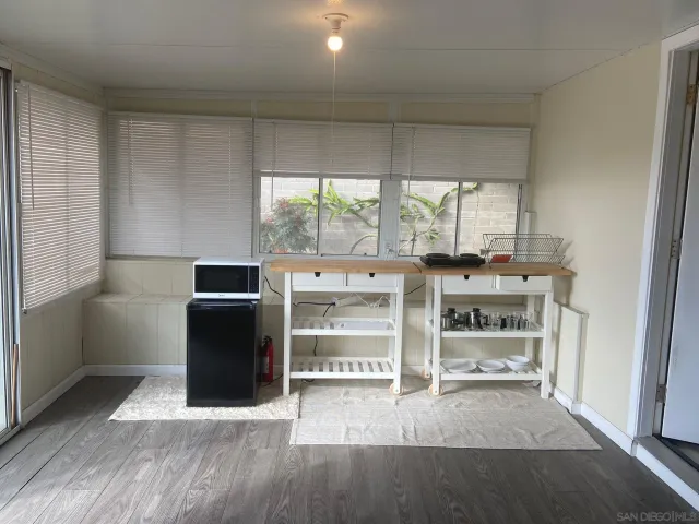 a view of a kitchen with fridge and wooden floor