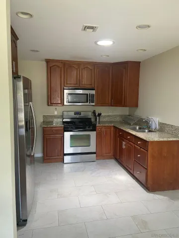 a kitchen with stainless steel appliances granite countertop a stove microwave and refrigerator