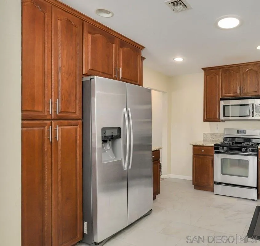 5442 San Onofre Terrace San Diego, CA 92114 - Photo 6 of 29 a metallic refrigerator freezer sitting in a kitchen