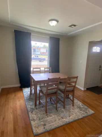 a dining room with furniture and wooden floor