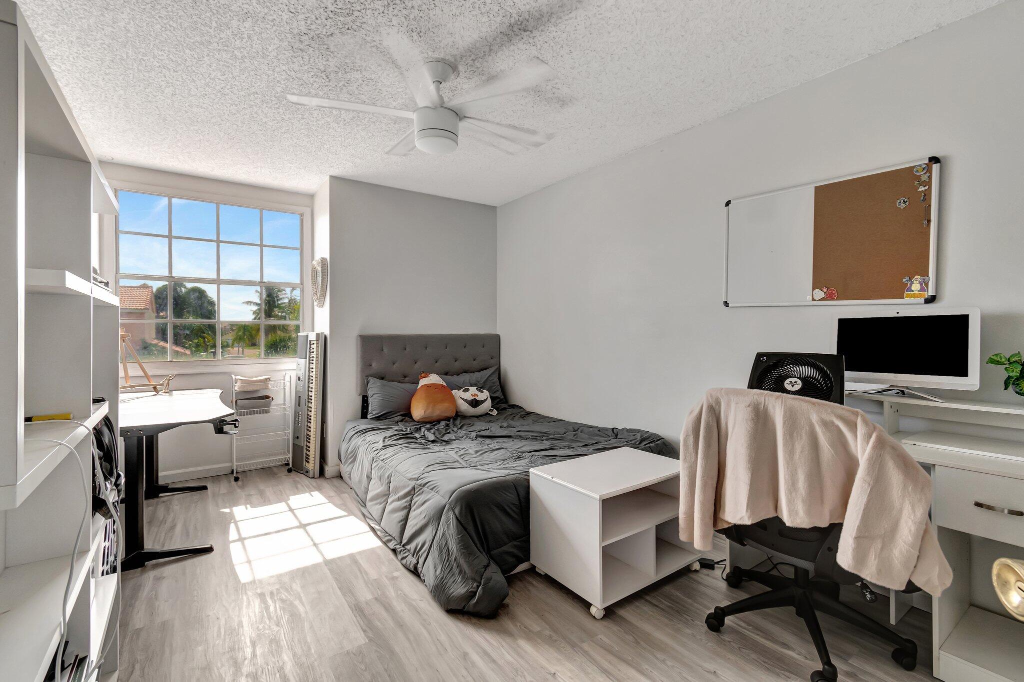 8557 Windy Circle Boynton Beach, FL 33472 - Photo 8 of 11 a bedroom with furniture and a flat screen tv