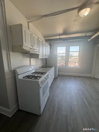 a kitchen with granite countertop a sink dishwasher a stove and a refrigerator