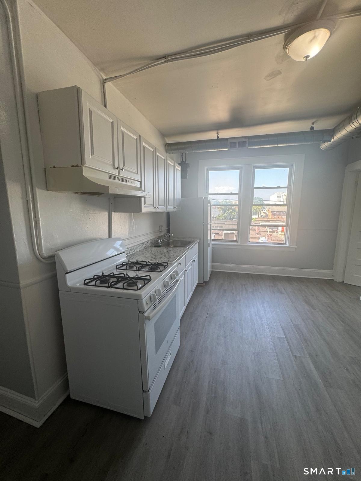 159 Charles Street Bridgeport, CT 06606 - Photo 1 of 4 a kitchen with granite countertop a sink dishwasher a stove and a refrigerator
