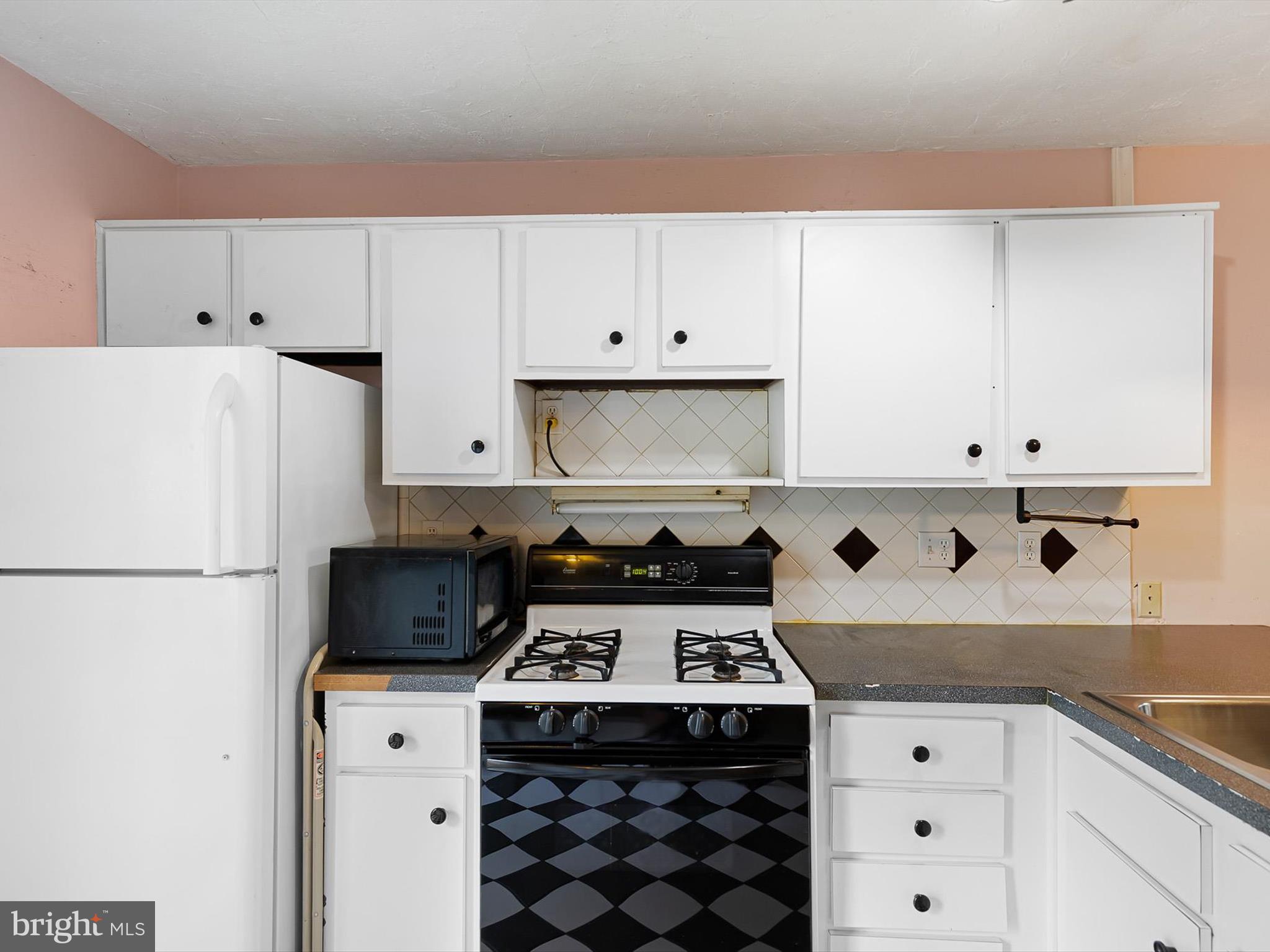 5 Topaz Drive Newark, DE 19702 - Photo 11 of 28 a kitchen with a white stove top oven and white cabinets
