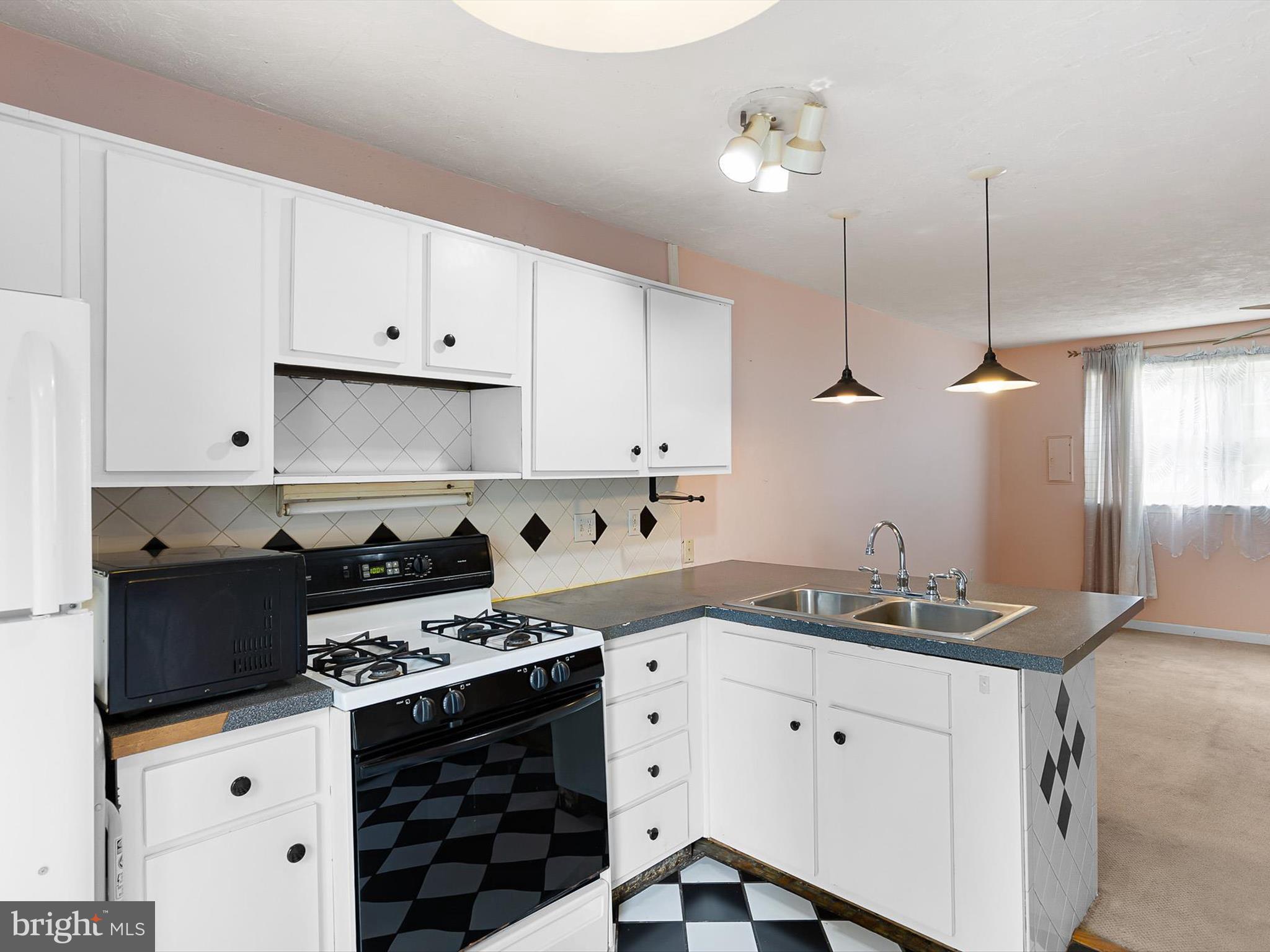 5 Topaz Drive Newark, DE 19702 - Photo 12 of 28 a kitchen with granite countertop a stove a sink and dishwasher with white cabinets