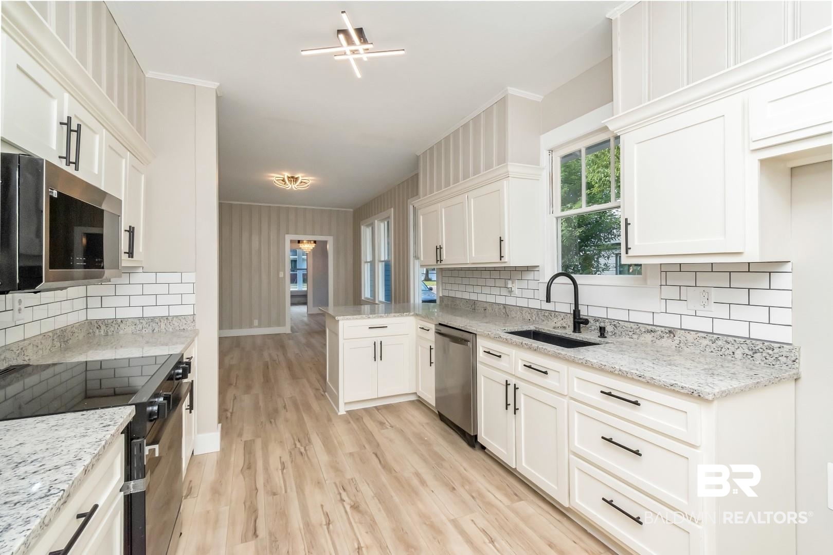 555 Michigan Avenue Mobile, AL 36604 - Photo 5 of 28 Kitchen featuring stainless steel appliances, backsplash, sink, light hardwood / wood-style floors, and white cabinets