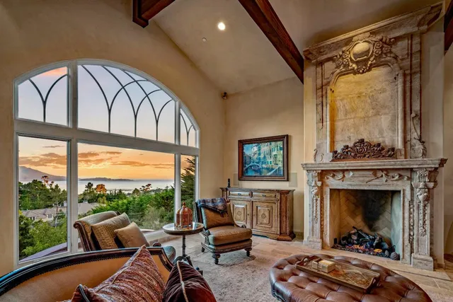 a living room with furniture fireplace and floor to ceiling windows