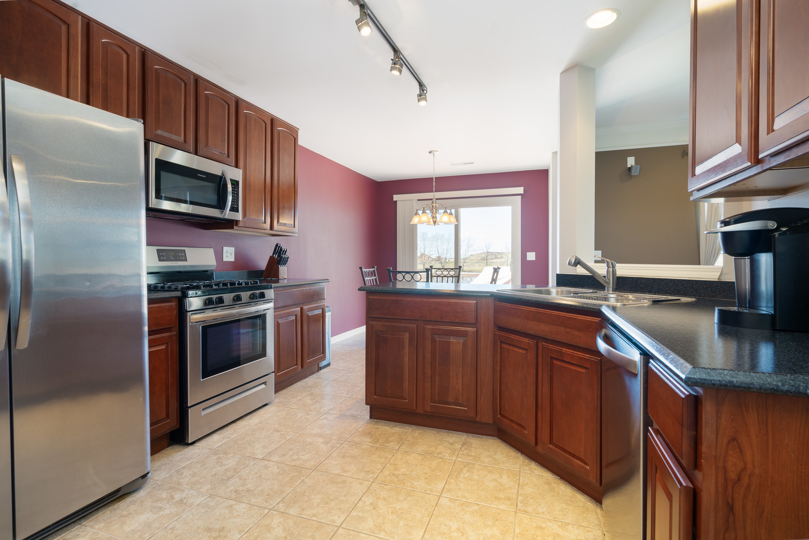 15316 Pinewood Road Lockport, IL 60441 - Photo 7 of 31 a kitchen with stainless steel appliances kitchen island granite countertop a sink stove and refrigerator