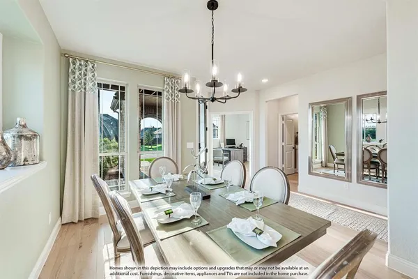 a dining room with wooden floor a chandelier a wooden table and chairs