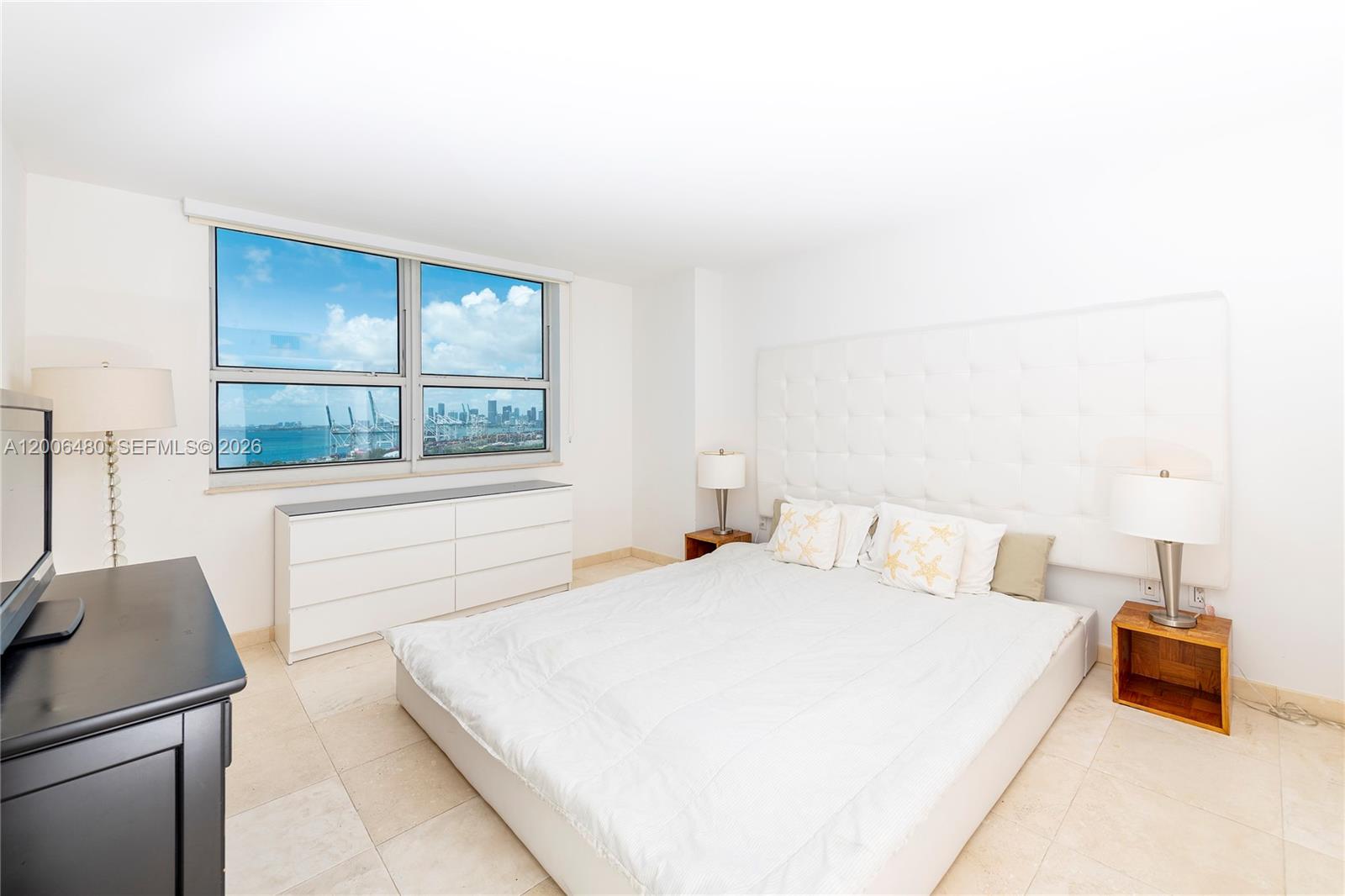 90 Alton Road, Unit 2304 Miami Beach, FL 33139 - Photo 12 of 16 a bedroom with a bed and wooden floor