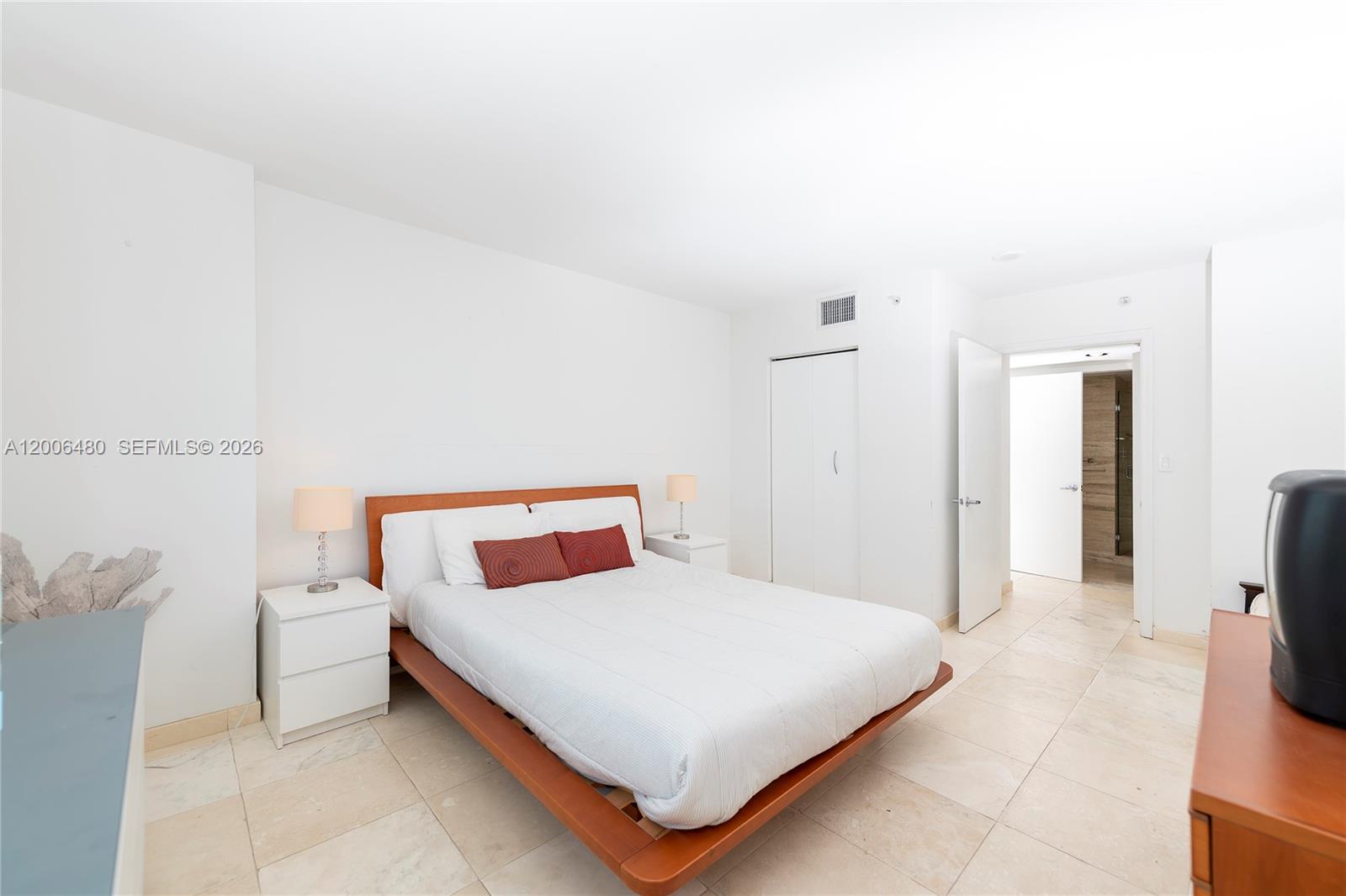 90 Alton Road, Unit 2304 Miami Beach, FL 33139 - Photo 13 of 16 a bedroom with a bed and a view of bathroom