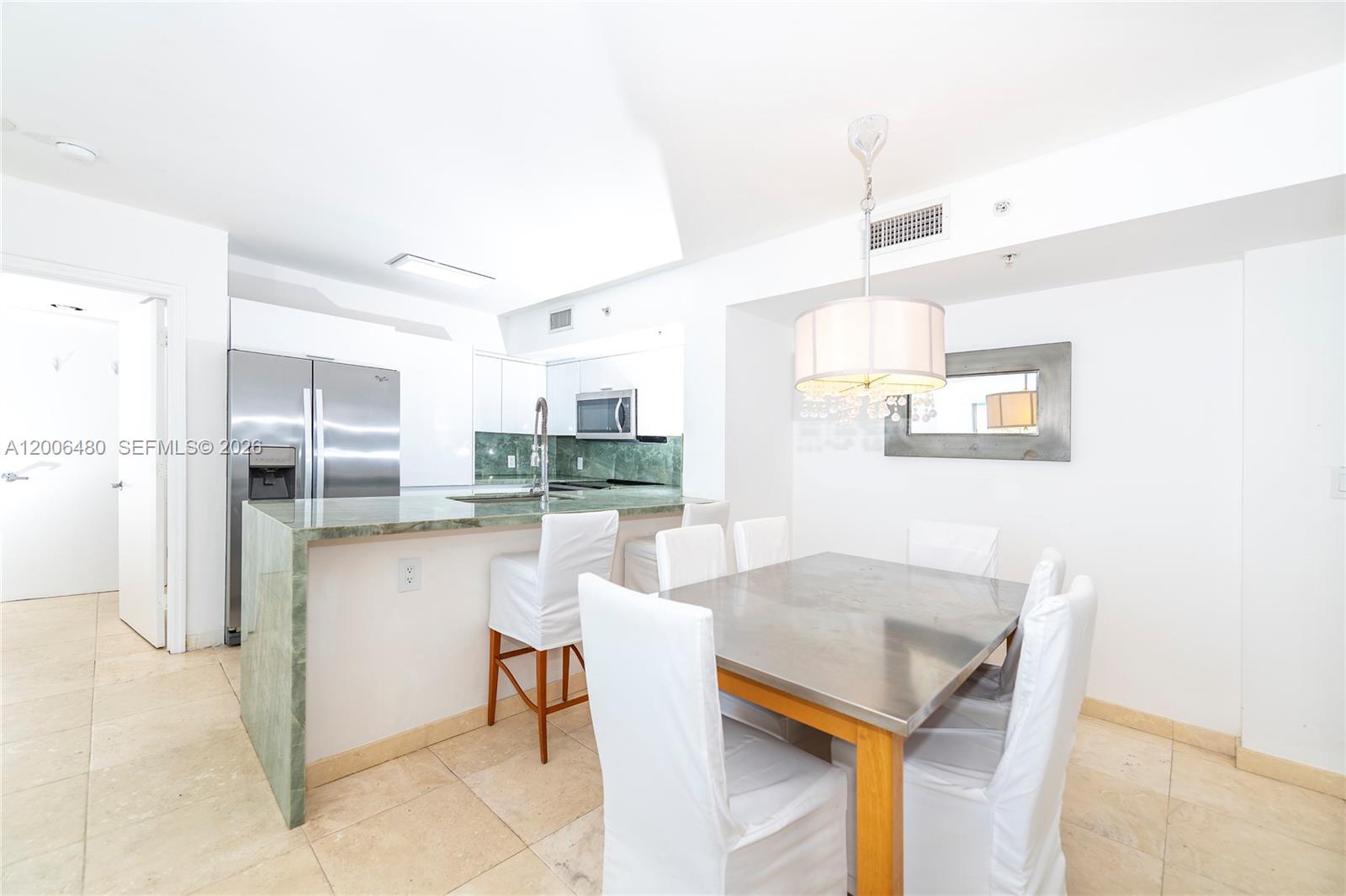 90 Alton Road, Unit 2304 Miami Beach, FL 33139 - Photo 3 of 16 a kitchen with stainless steel appliances kitchen island granite countertop a refrigerator and microwave