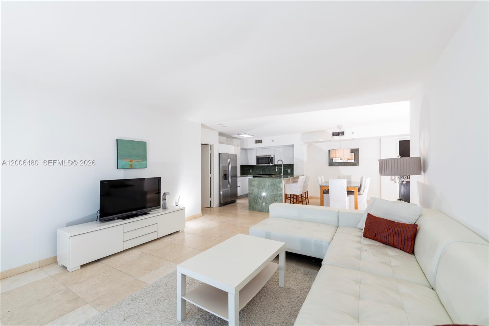90 Alton Road, Unit 2304 Miami Beach, FL 33139 - Photo 6 of 16 a living room with furniture and a flat screen tv
