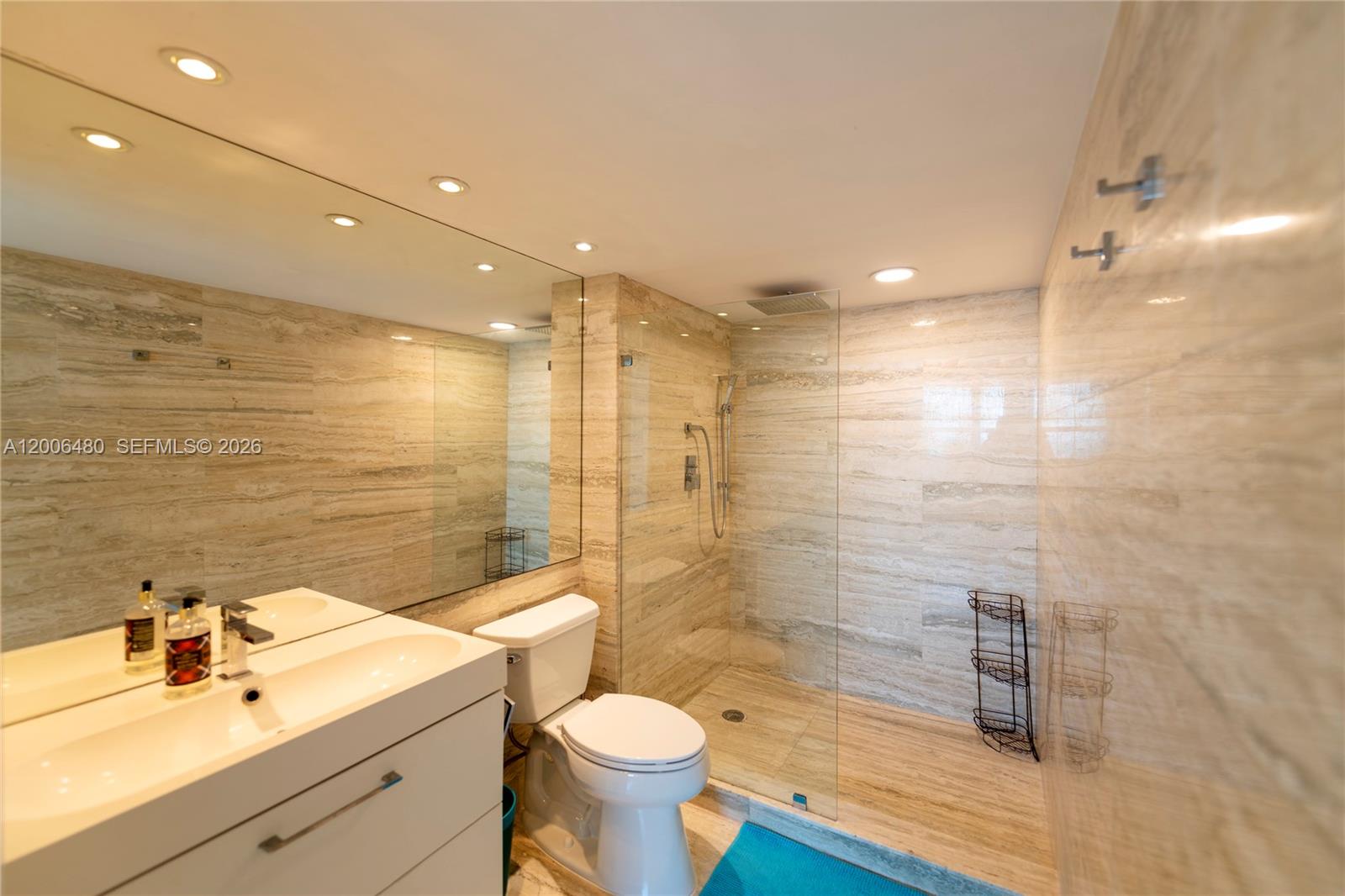 90 Alton Road, Unit 2304 Miami Beach, FL 33139 - Photo 8 of 16 a bathroom with a sink toilet a mirror and shower