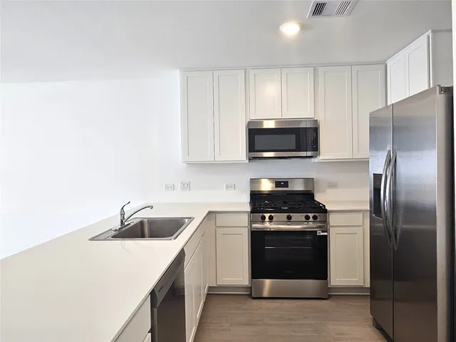 a kitchen with a sink stove and refrigerator