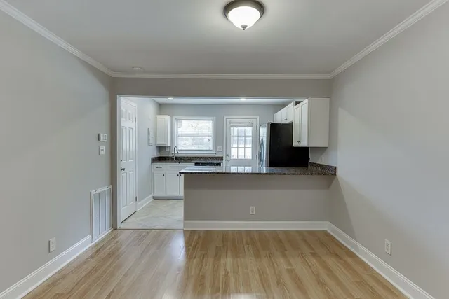 a view of a kitchen with granite countertop cabinets and wooden floor
