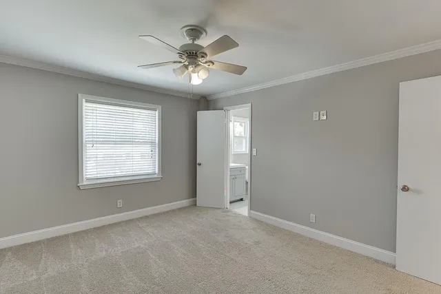 a view of an empty room and a ceiling fan window