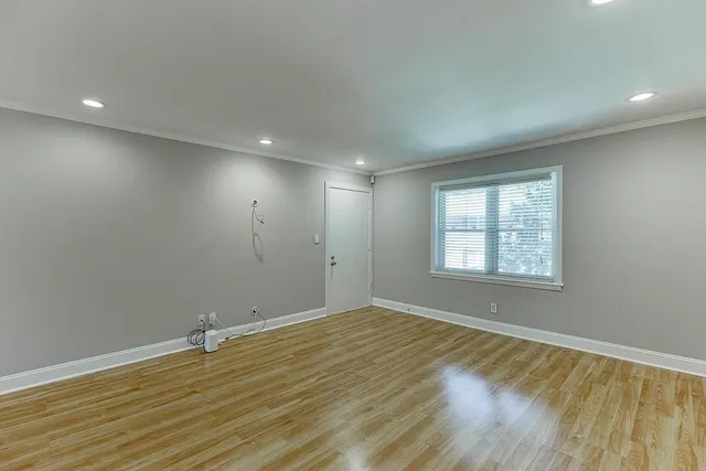 a view of empty room with wooden floor