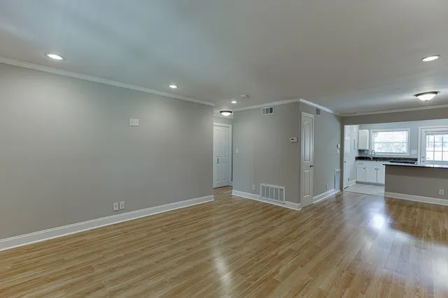 a view of empty room with wooden floor