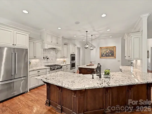 a kitchen with granite countertop a sink appliances and cabinets