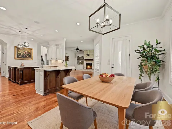 a kitchen with stainless steel appliances granite countertop a table and chairs in it