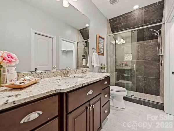 a view of swimming pool with lawn chairs and plants