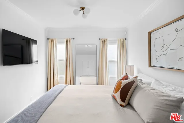 a bedroom with a bed and a flat screen tv