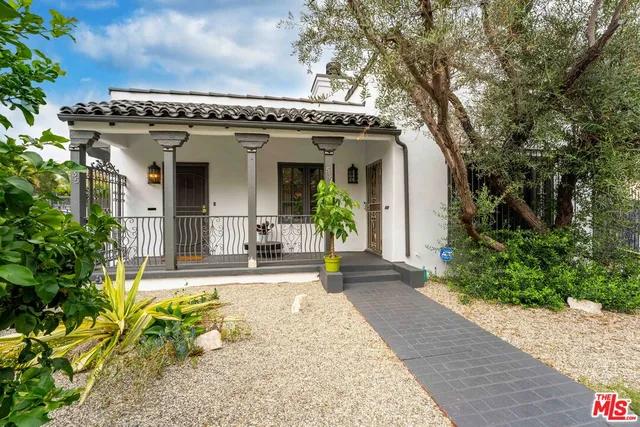 a view of a building with potted plants and a bench