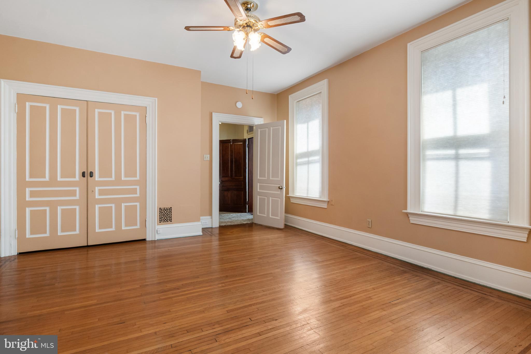 721 South George Street York, PA 17401 - Photo 33 of 78 an empty room with wooden floor chandelier fan and windows