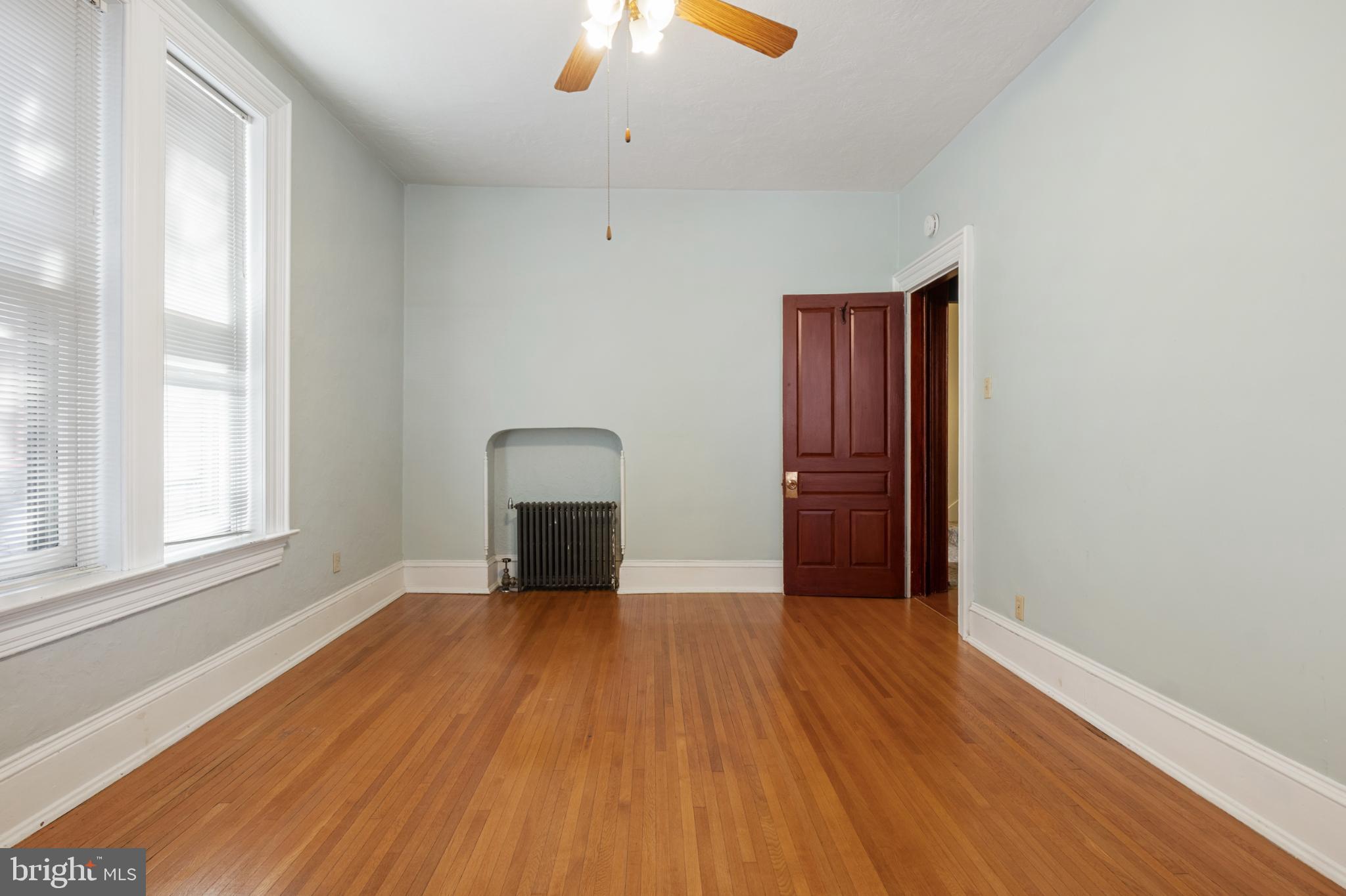 721 South George Street York, PA 17401 - Photo 38 of 78 an empty room with wooden floor chandelier fan and windows