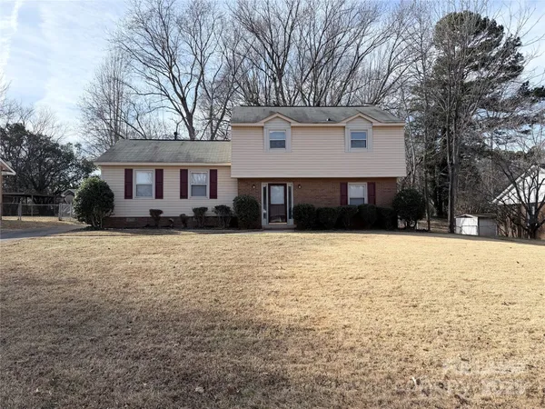 a front view of a house with a yard covered in snow