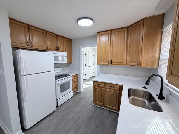 a kitchen with a refrigerator sink and cabinets