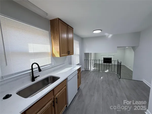 a kitchen with a sink and wooden floor