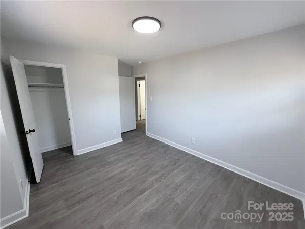 an empty room with wooden floor and window