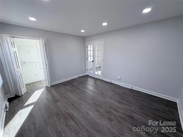 an empty room with wooden floor and a window