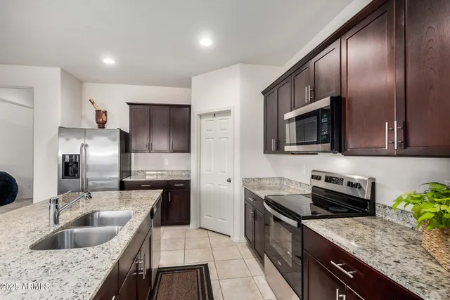 a kitchen with stainless steel appliances granite countertop a sink stove and refrigerator