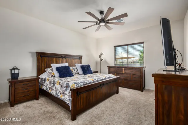 a bedroom with a bed and a flat tv screen on the dresser