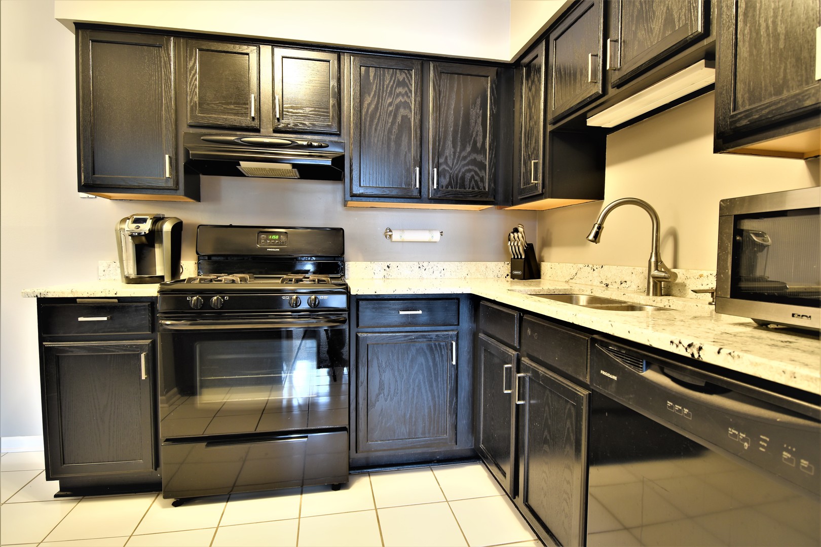 19330 Wolf Road, Unit 5 Mokena, IL 60448 - Photo 9 of 25 a kitchen with granite countertop wooden cabinets and black appliances