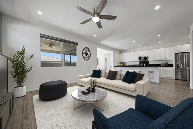 a living room with furniture kitchen view and a potted plant