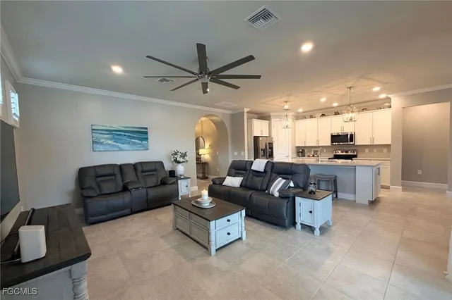 a kitchen with a refrigerator a sink dishwasher a dining table and chairs with wooden floor